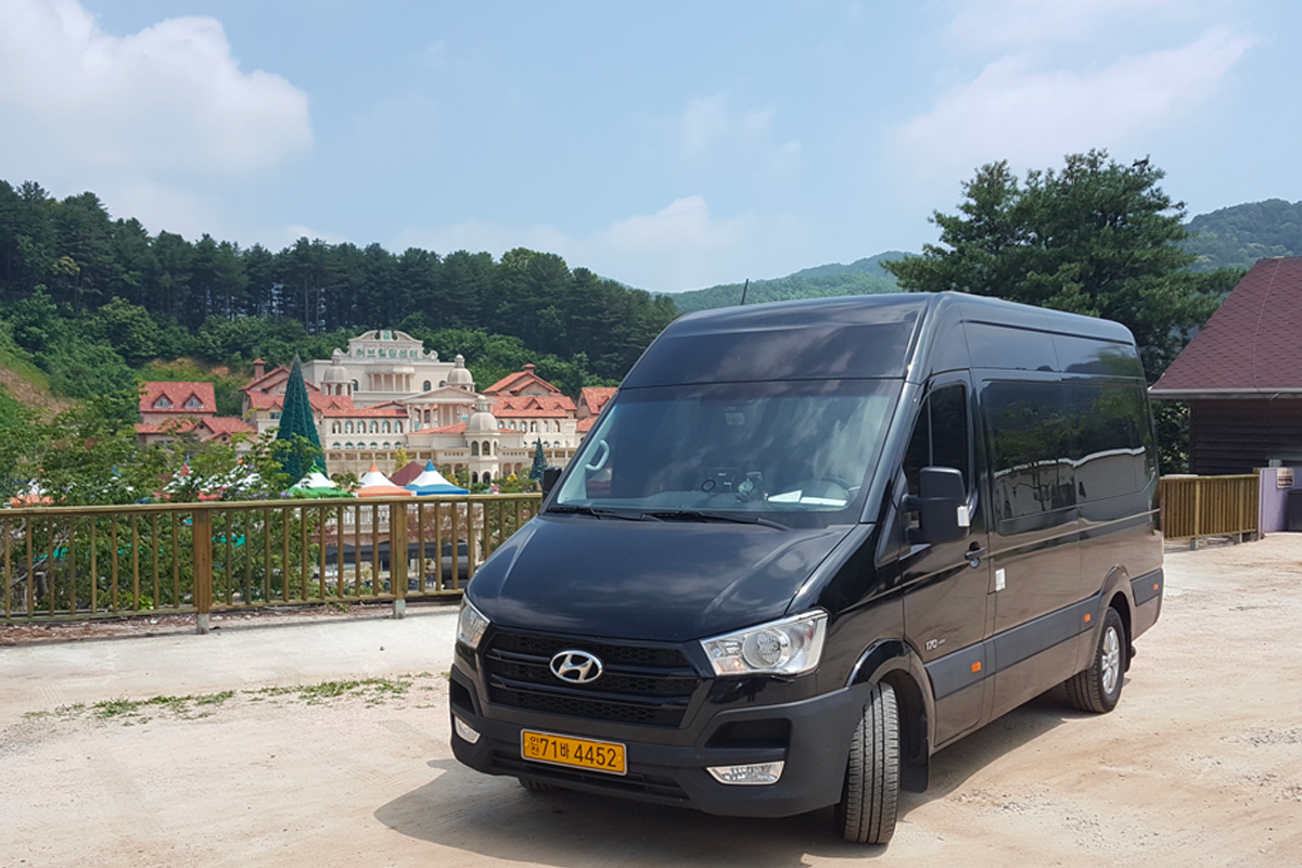 現代大型旅遊車在風景優美的地方停靠,提供韓國仁川和金浦機場接送及包車服務。