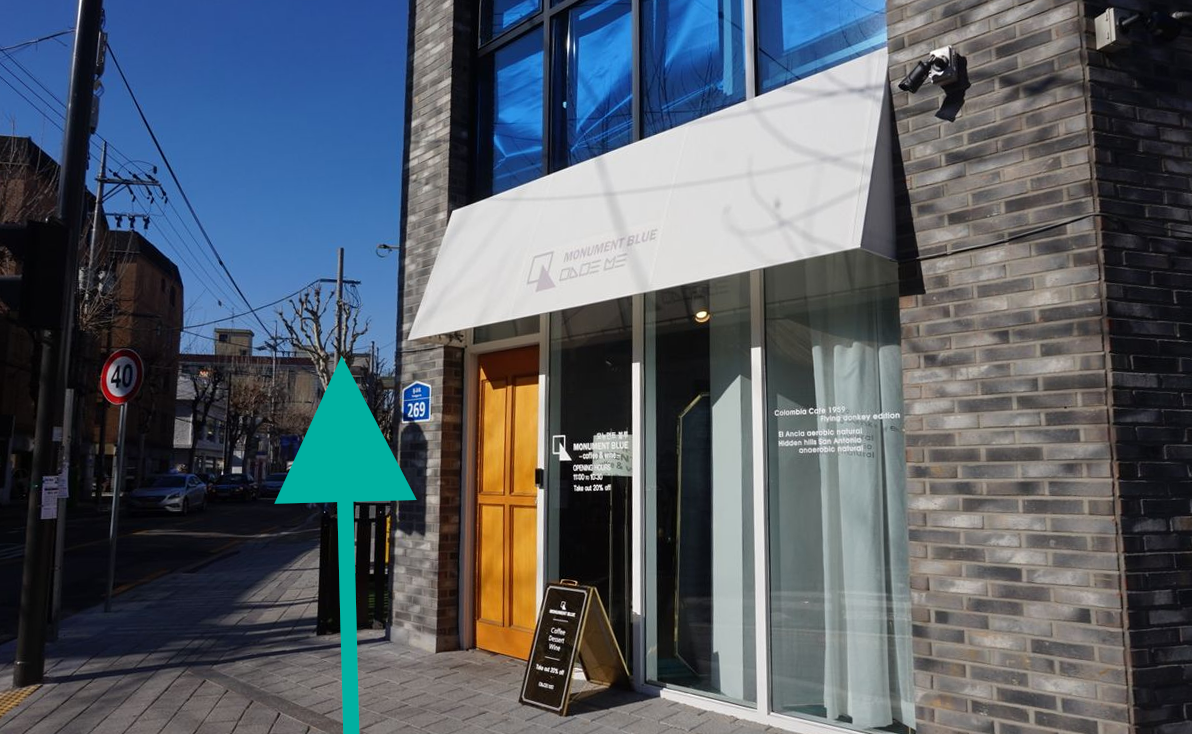 文艺咖啡厅街道上展示一个黄木门建筑,作为向延南洞Café Highwaist步行探索的小巷入口。