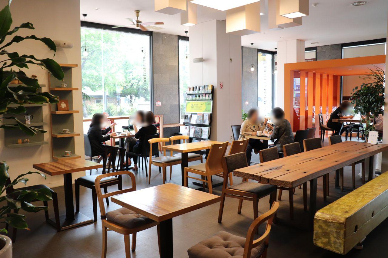 大邱のカフェ名家のカフェ内部の写真。木製のテーブルと椅子で、落ち着いた雰囲気が漂っています。