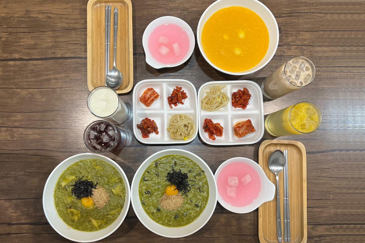 松竹餐廳桌上的多樣經典韓式粥品，配有多種韓式小菜和飲品。