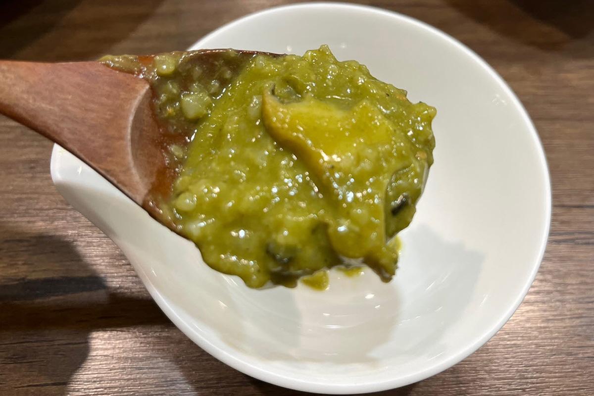 松竹餐廳以木勺攪拌鮮美的韓式粥品，展現其濃鬱的質感。