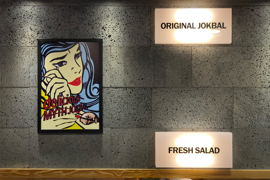 豬腳小姐餐廳內部，牆上有復古風格的藝術畫與豬腳廣告，增添了店內氛圍。