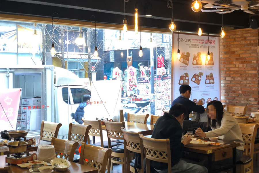 豬腳小姐餐廳內部寬敞的用餐區，透過大窗可看見明洞的街道景色，適合休閒用餐。