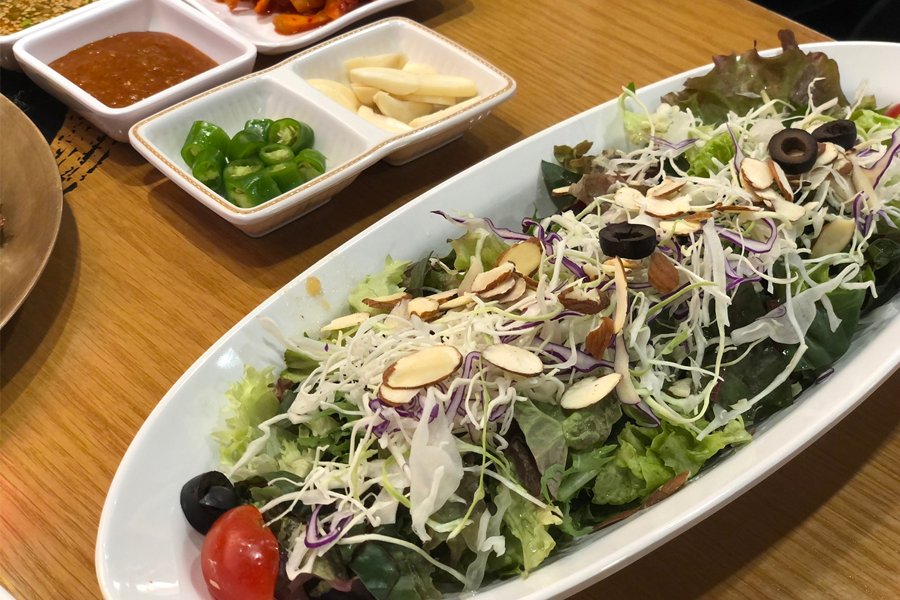 份量充足的沙拉，配有新鮮的蔬菜和杏仁片，提供清爽的味覺享受。