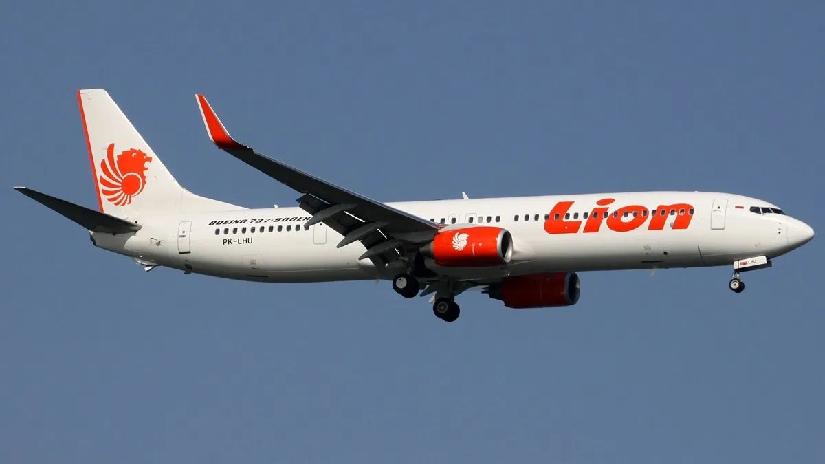 เครื่องบินของ Thai Lion Air บนท้องฟ้าสว่าง พร้อมโลโก้สีส้มบนหางเครื่องบิน 