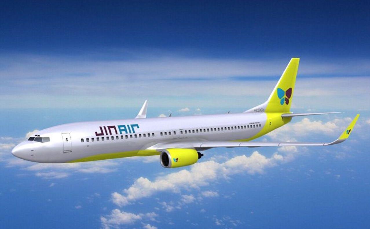 เครื่องบินของ Jin Air กับโลโก้สีเขียวและฟ้าอยู่บนท้องฟ้าสดใส 