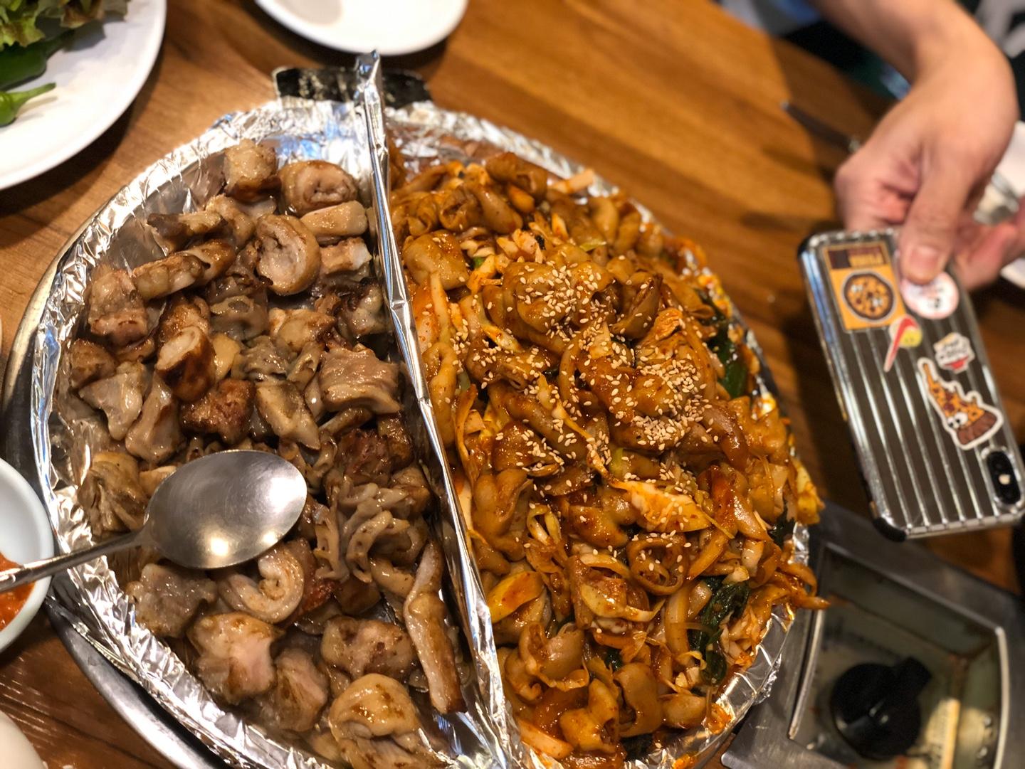 放滿韓式烤腸與辛辣蔬菜拌腸的桌子，搭配不同的韓式醬料，展現出Jungbu家烤腸的多樣性和美味。