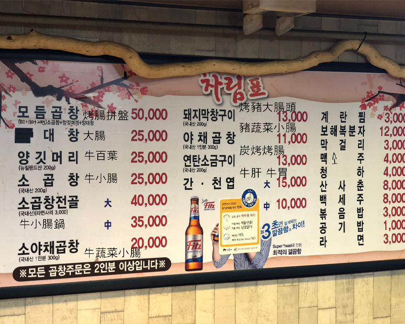 餐廳牆上的菜單展示了各種特色韓式烤腸的價格，讓顧客有多種選擇。