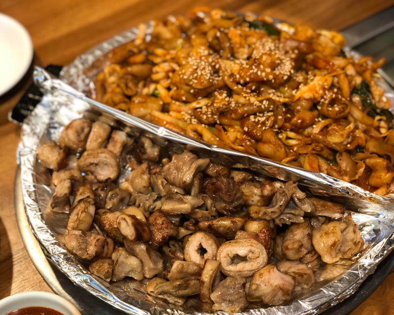 豐盛的烤腸盛盤，一半是香辣紅色調理的蔬菜小腸，另一半是酥脆的無調料烤腸。