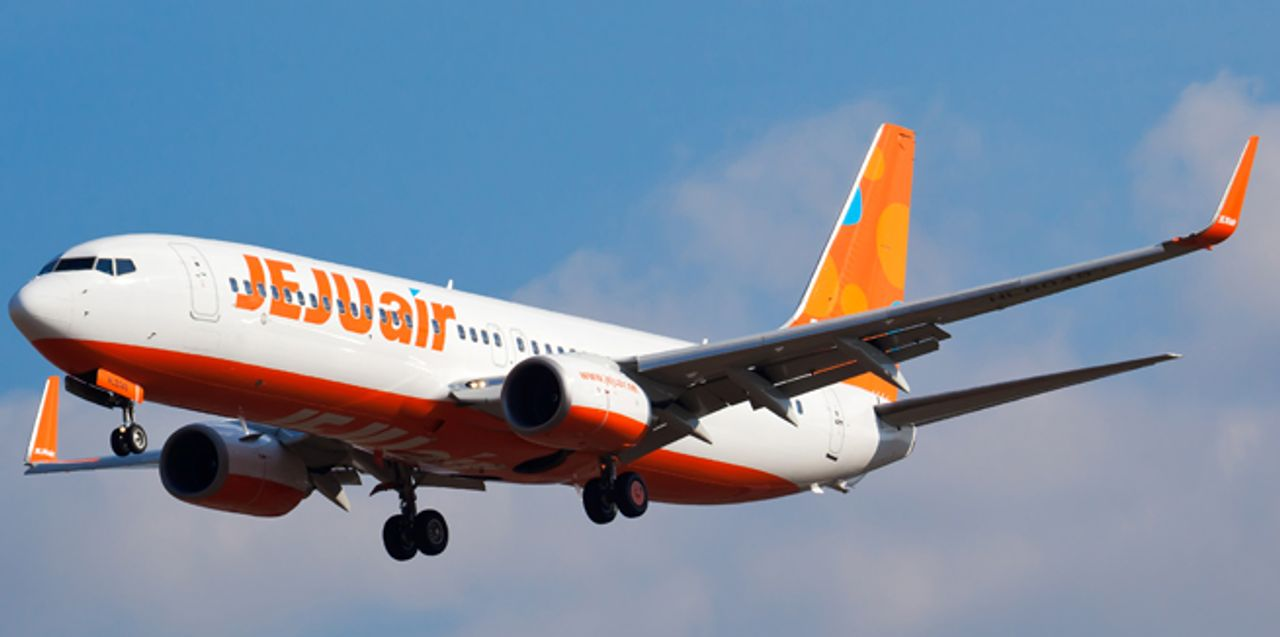 ภาพเครื่องบินของสายการบินเชจูแอร์ สายการบินราคาประหยัดชั้นนำของเกาหลี บนท้องฟ้าพร้อมแสงอาทิตย์สดใส ขณะทำการบิน