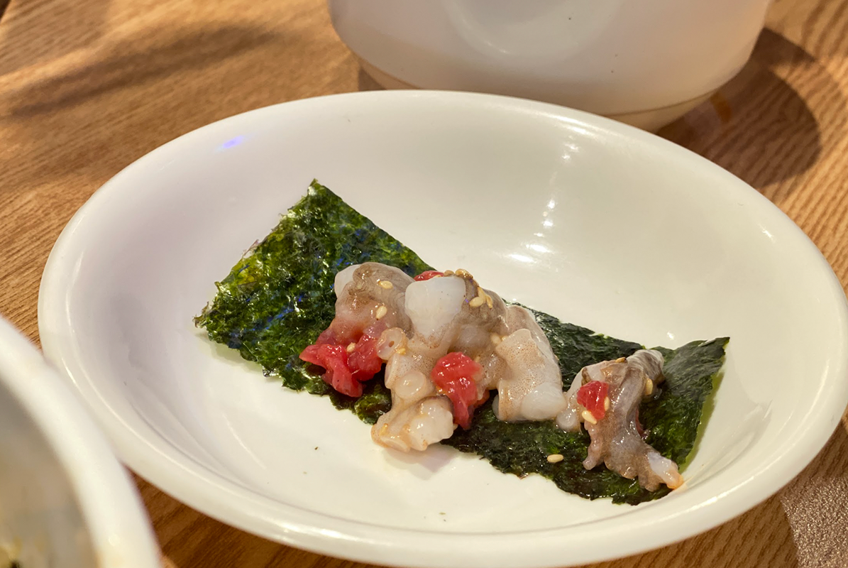 一道將生牛肉和活章魚包裹在紫菜中的創意料理，這樣的搭配呈現出韓國料理的獨特和美味。