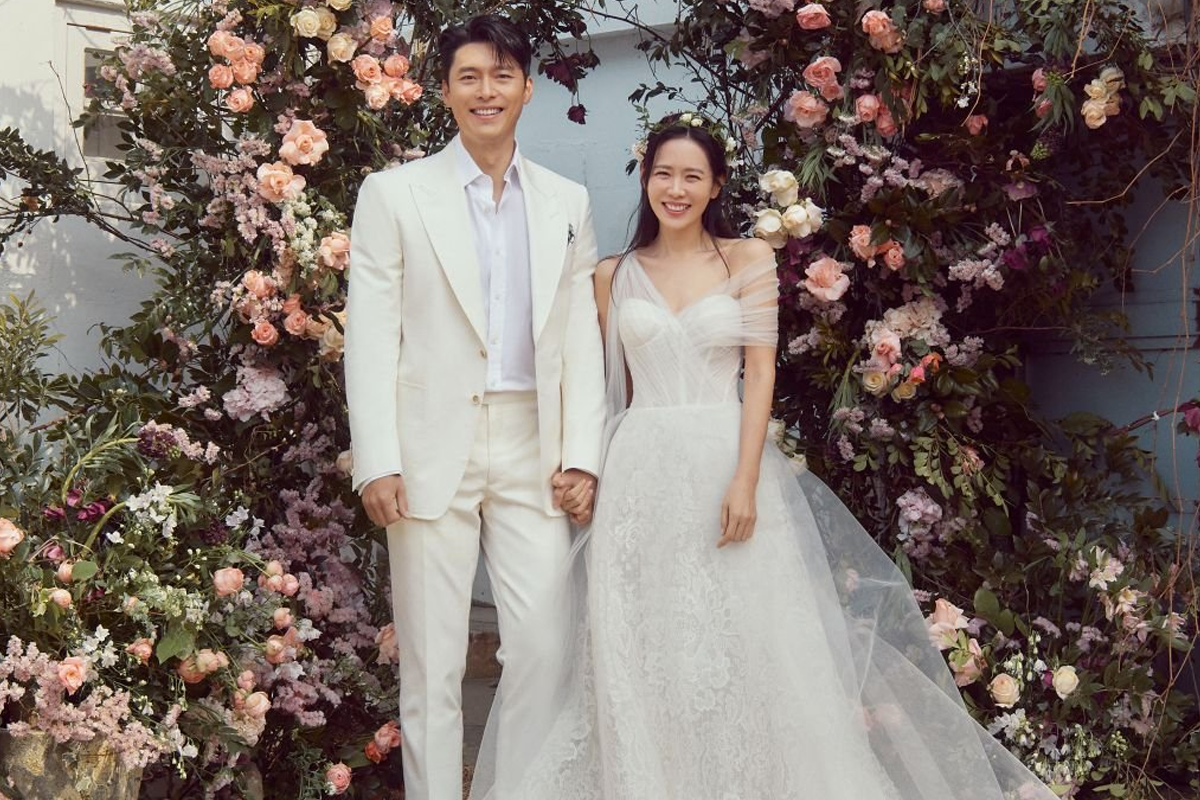 玄彬穿著白色西裝的婚禮照片，背景擺滿鮮花。