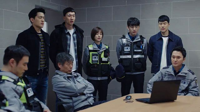 一羣人在房間裡與穿著制服的安全人員對峙的場景。