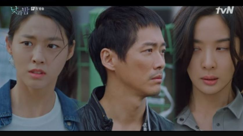 韓国ドラマ『昼と夜』の一場面。オフィスにいるキャラクター達が真剣な表情で会話をしている。薄暗い室内の中で怪しい雰囲気が漂っている。