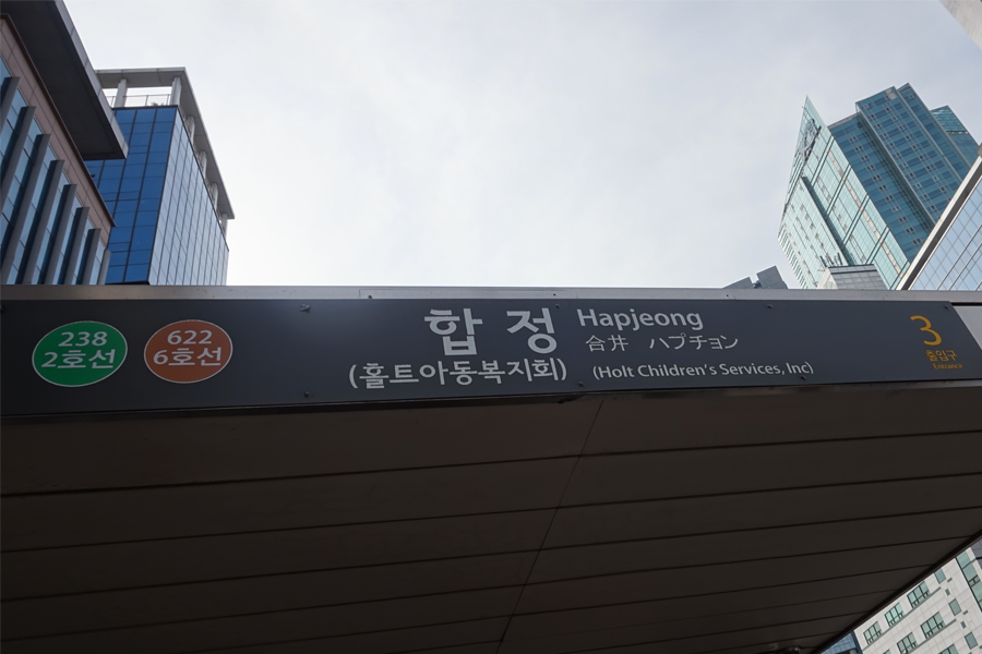 從合井站步行前往 AM:TON 髮廊的路上，路人和商店沿街排列，街景活躍。