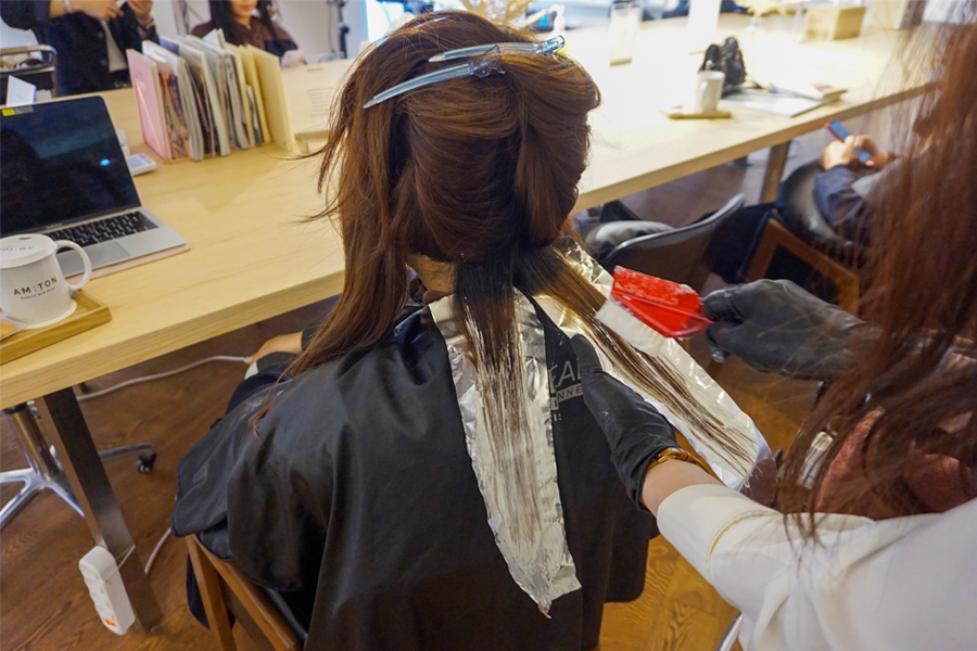 在 AM:TON 髮廊，顧客在洗髮椅上進行護髮，放鬆舒適的氛圍。