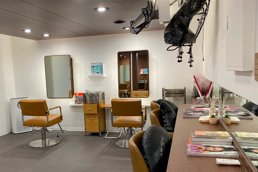 AM:TON 的洗護發區，配有舒適椅子，牆上陳列各種護髮產品，專業服務讓顧客安心。