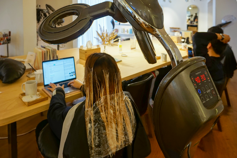 染髮劑被均勻塗抹在頭髮上，顯示 AM:TON 髮廊的專業服務。