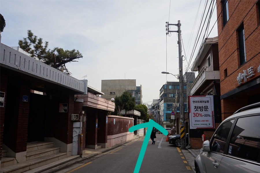 靠近 AM:TON 的巷道，周遭有建築和停車位，顯示其在市區的便捷位置。