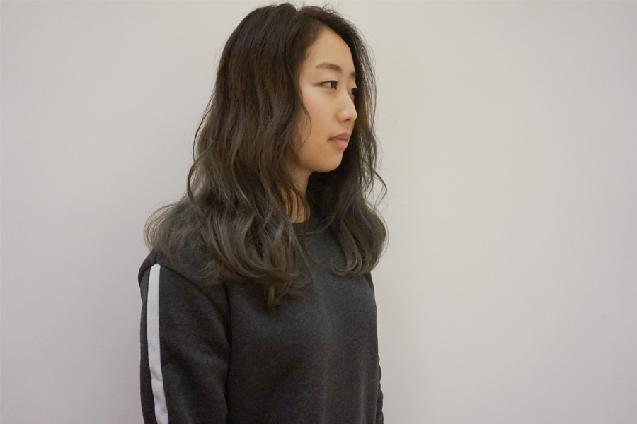 顧客在鏡前檢視新染髮色，欣賞 AM:TON 的美髮技術和細緻效果。