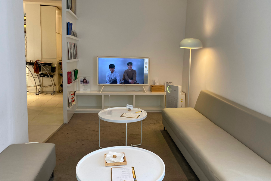 AM:TON 髮廊的休息區，內有電視和舒適座椅供顧客放鬆，環境寧靜舒適。