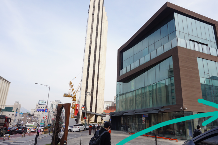 前往 AM:TON 髮廊的巷道入口，沿路有建築物和樹木環繞，安靜的鄰裡環境。