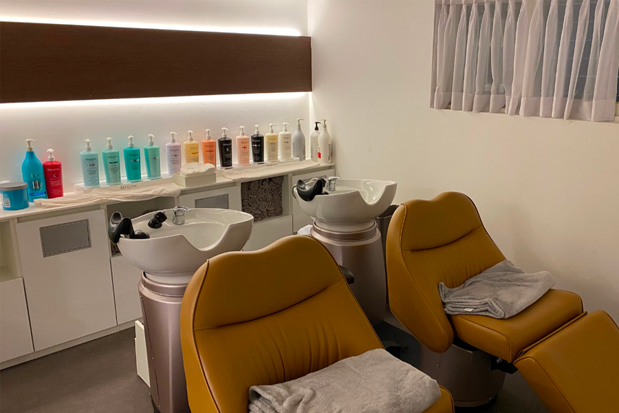 AM:TON 髮廊的廁所設施，擺放著清潔用品，環境乾淨整潔。