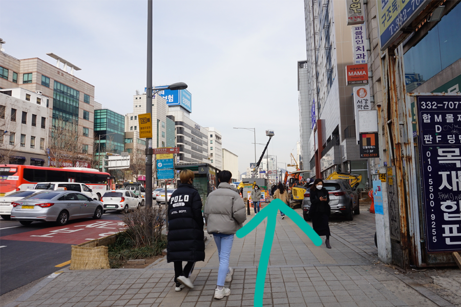 走過街道的一個分叉口，指引顧客前往 AM:TON 髮廊，沿途設有商店和高樓。