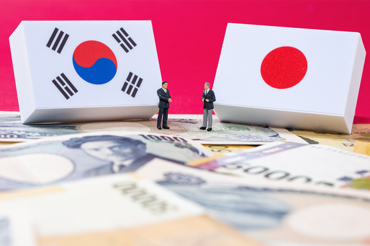 韩国与日本国旗下代表人物模型在货币背景上对峙