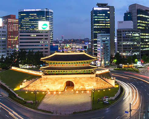 现代崇礼门在夜间的样貌，周围高楼与市中心灯光璀璨