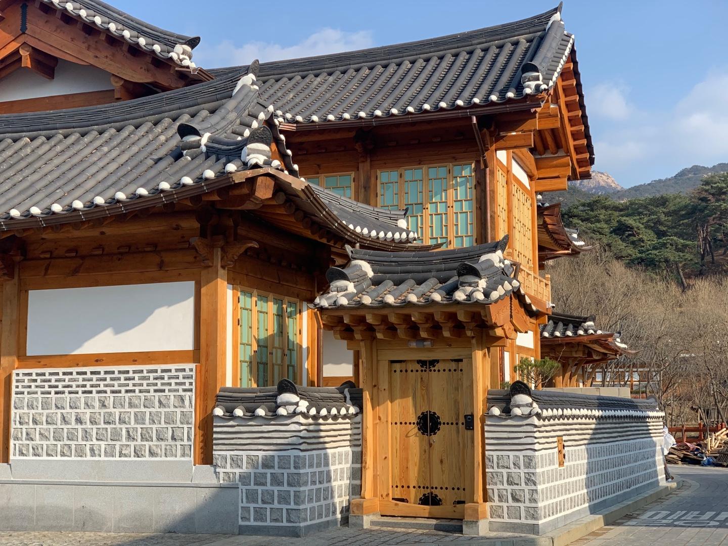 Close-up view of a meticulously crafted hanok house in Eunpyeong Hanok Village showcasing wooden features, stone walls, and traditional Korean roof tiles.
