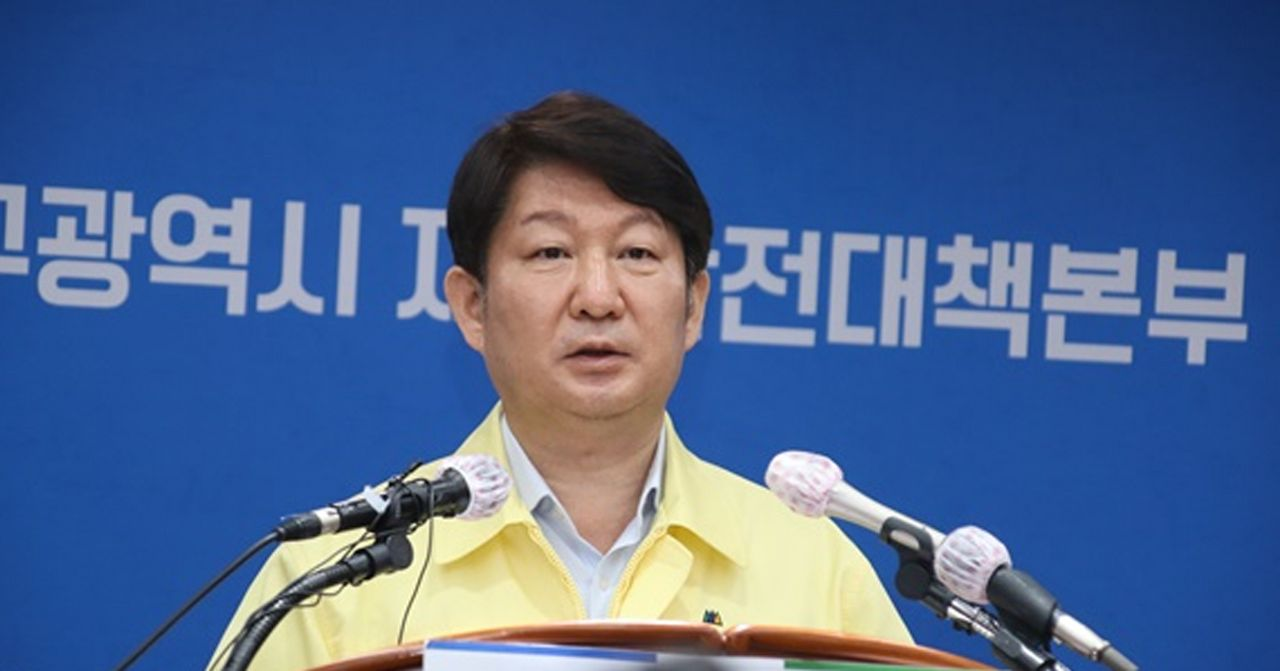 韓國市政官員在媒體前説明疫情防控策略，背景為官方標誌。