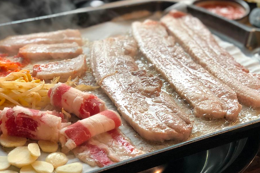 在韓國品嘗滋滋作響的三層肉，感受地道韓式美食的魅力。