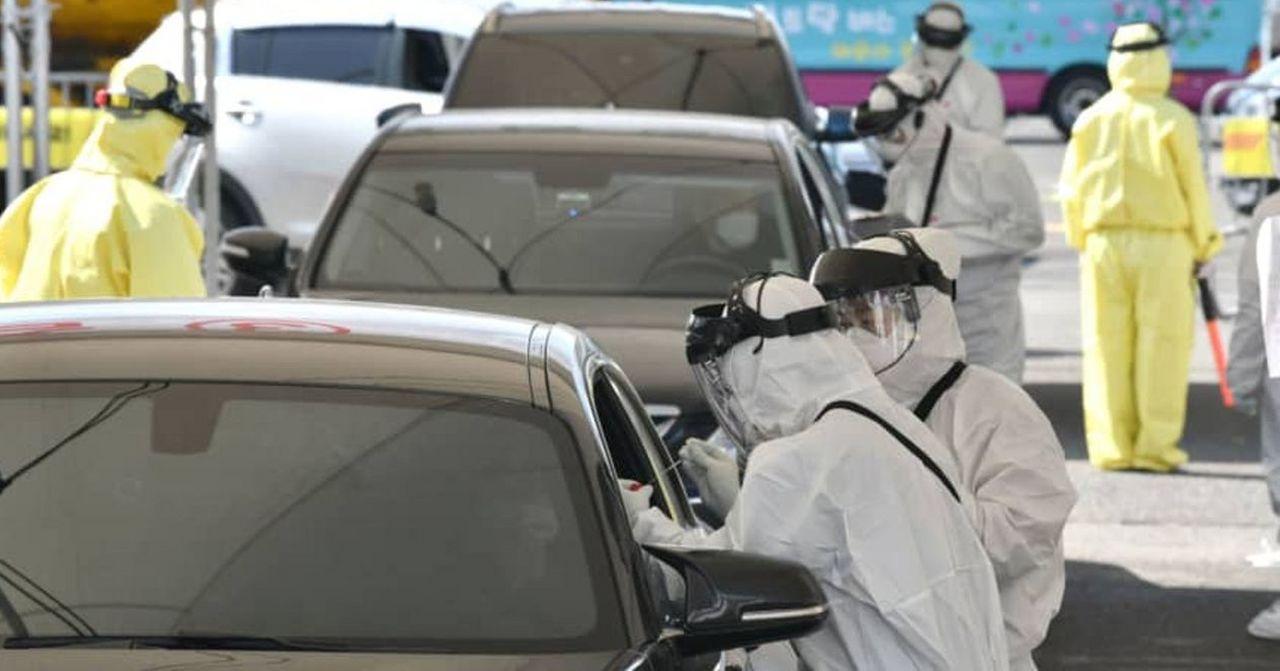 韓國疫情期間嘅Drive Thru檢測站，醫護人員著全身防護裝為車中乘客進行新型肺炎檢測。