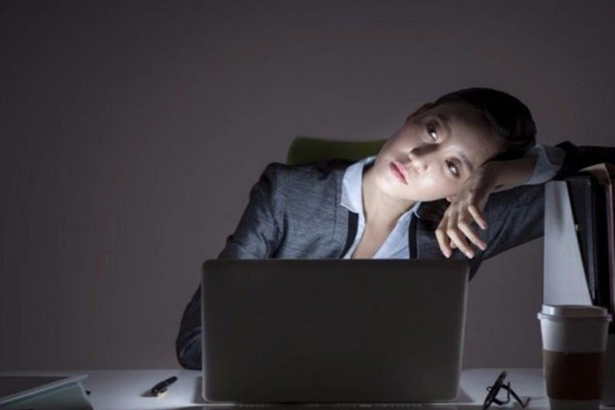 韩国女性在职场上因压力过大而趴在电脑前休息的情景，象征着韩国职场中性别不平等的现象。