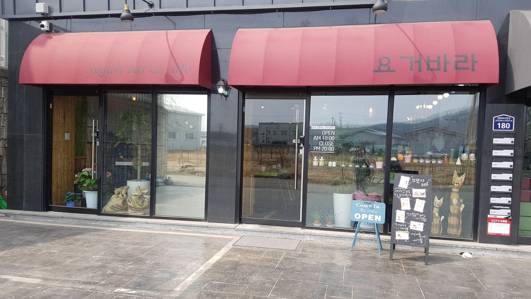 ภาพด้านหน้าของคาเฟ่ Yogeo Bara ในอิลซาน แสดงทัศนียภาพของร้านคาเฟ่และการตกแต่งด้วยกระจกและผนังไม้