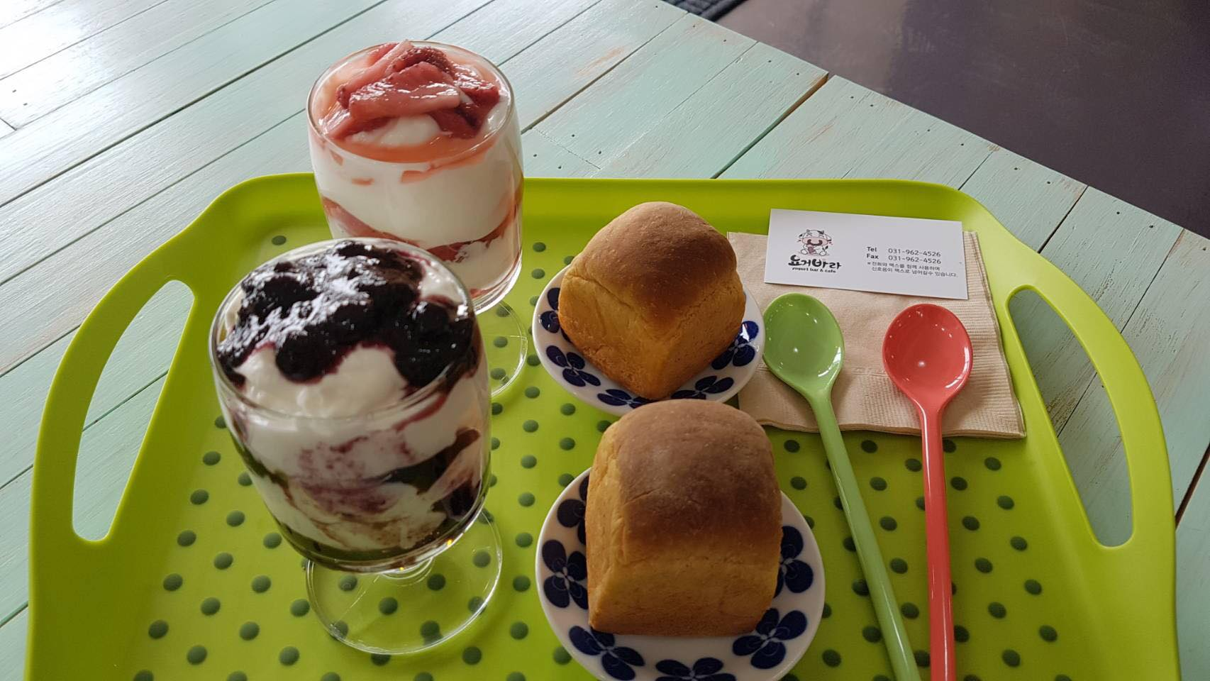 ถาดเสิร์ฟที่มีโยเกิร์ตบลูเบอร์รี่และสตรอเบอร์รี่พร้อมขนมปังมินิจากคาเฟ่ Yogeo Bara ในอิลซาน ประเทศเกาหลีใต้