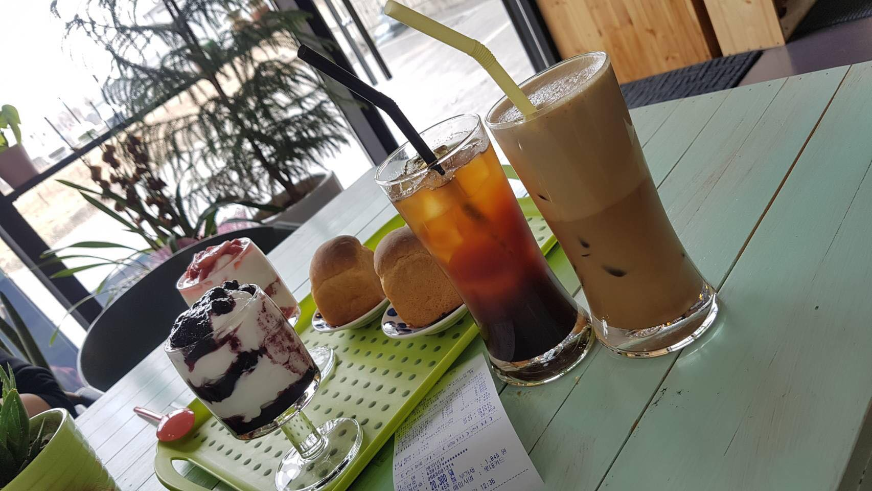 โต๊ะในคาเฟ่ Yogeo Bara ที่มีโยเกิร์ตและเครื่องดื่มต่างๆ พร้อมเสิร์ฟในอิลซาน ประเทศเกาหลีใต้