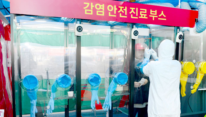 韓國Walking Thru檢測站，醫護人員在迷你負壓病房內進行檢測。