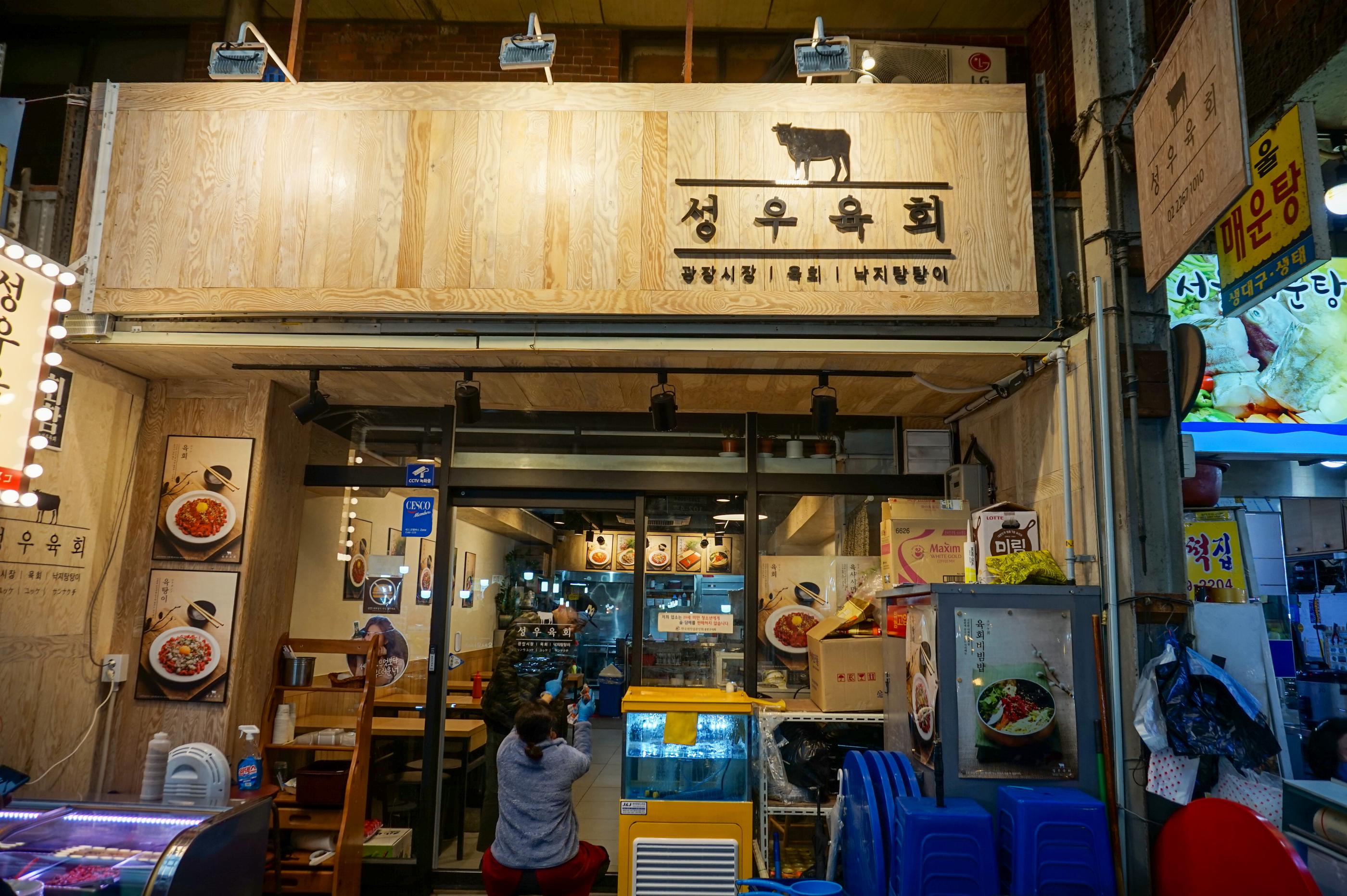 広蔵市場内を歩く人々の様子。店舗が並ぶ通りの全景が見える。