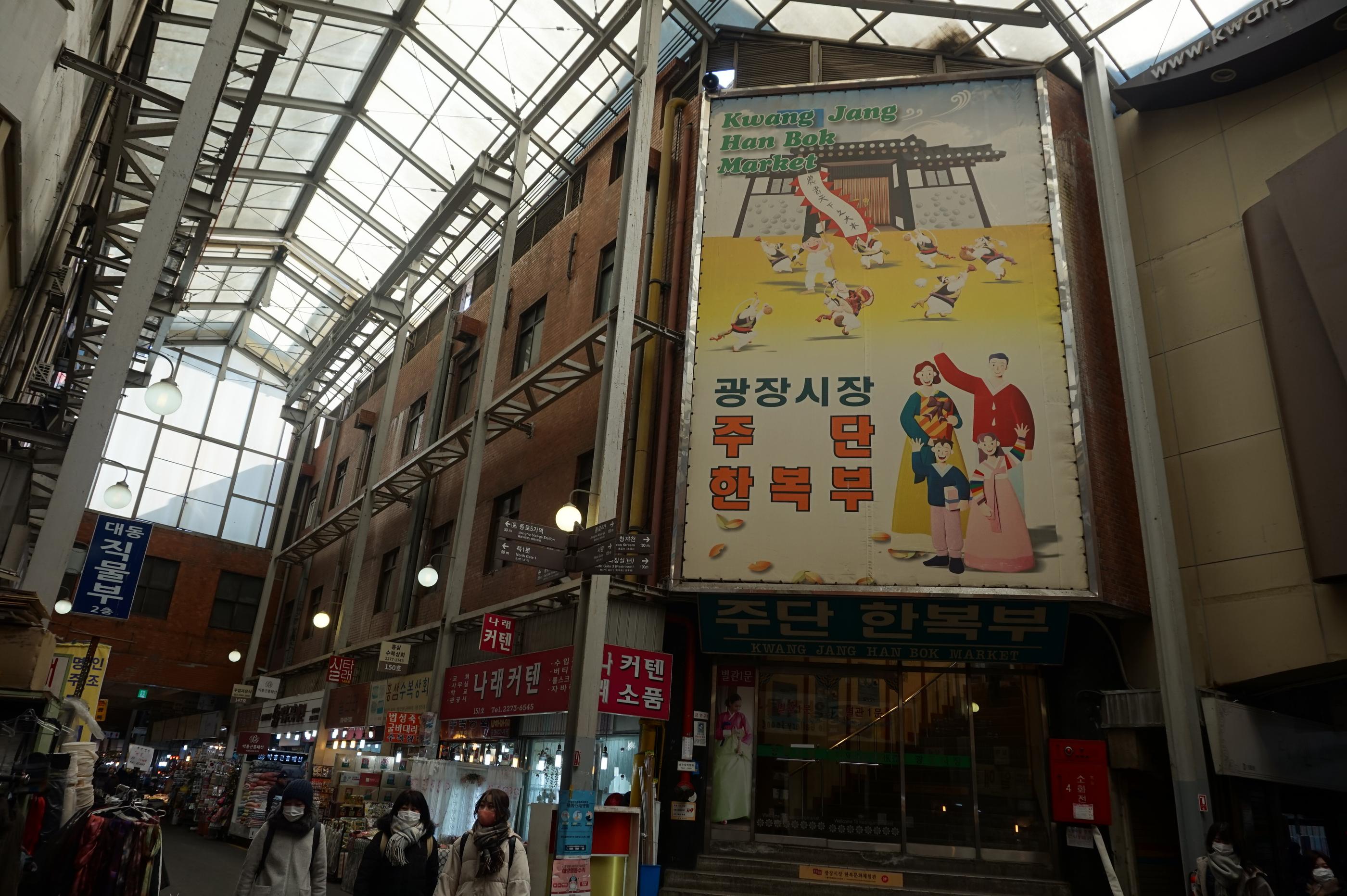 広蔵市場内にある大きな韓服の看板。広い通りに沿って様々な店舗が並ぶ。