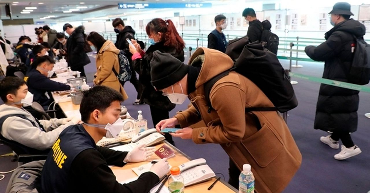 韩国机场内的安检过程中，人们排队等待入境检查。