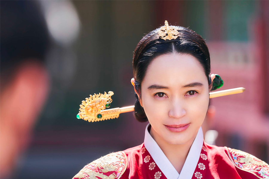 來自韓國古裝劇《王后傘下》的中殿場景，皇后戴著華麗的髮飾與服飾，展示出韓國傳統宮殿服飾的魅力。