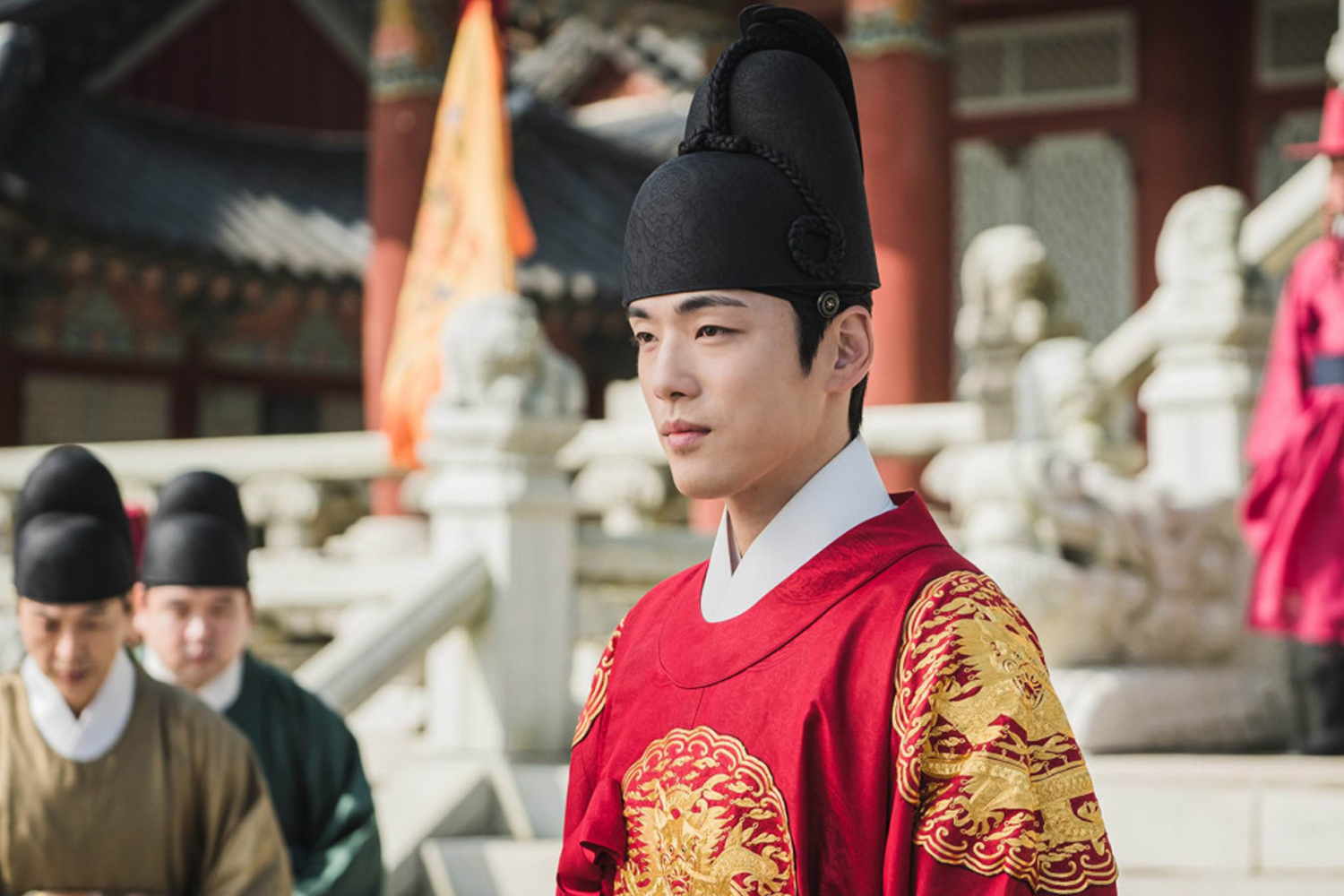 韓國古裝劇《屍戰朝鮮》中的王,穿著華麗的紅色服裝,站在宮殿前面。