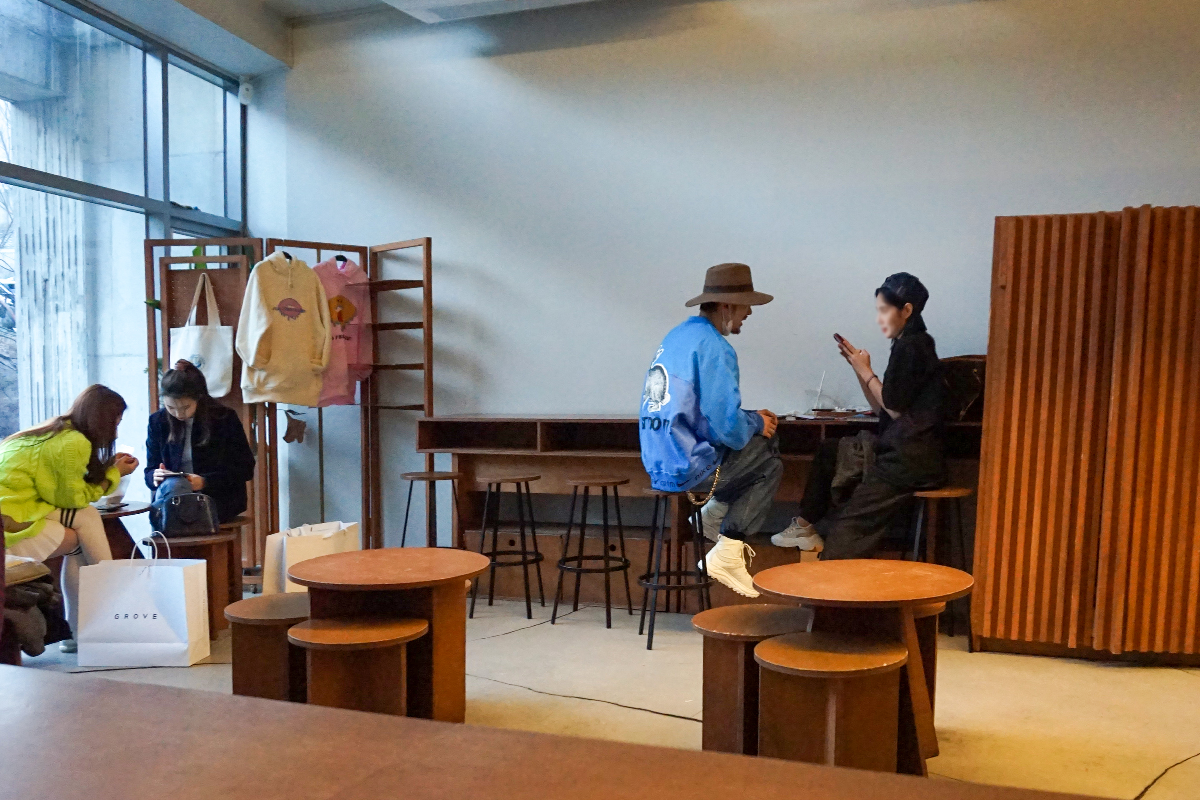 Old Ferry Donut咖啡馆客座区,摆放着现代风格的木桌椅,顾客们正在享受他们的咖啡和甜甜圈。