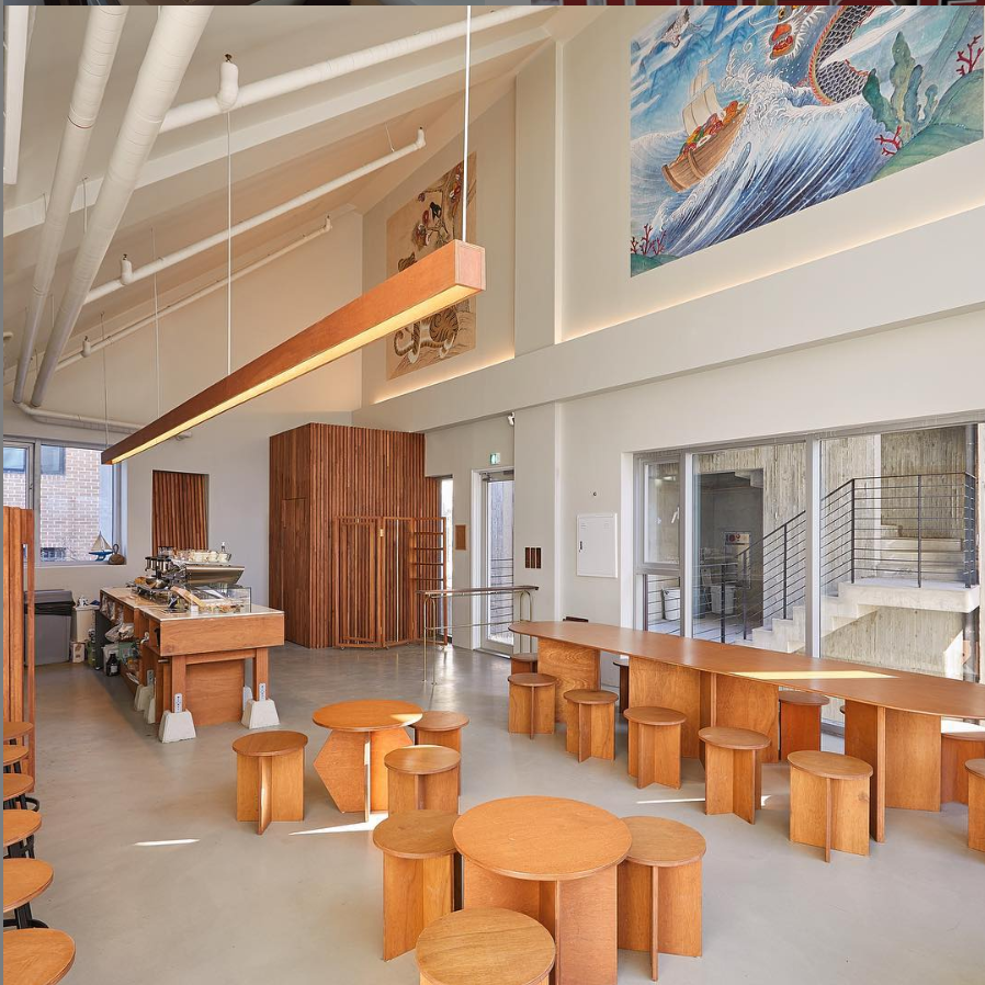 Old Ferry Donut咖啡馆的室内设计,采用大量木质元素,简约而温馨,墙上挂了一幅描绘帆船图案的艺术作品。