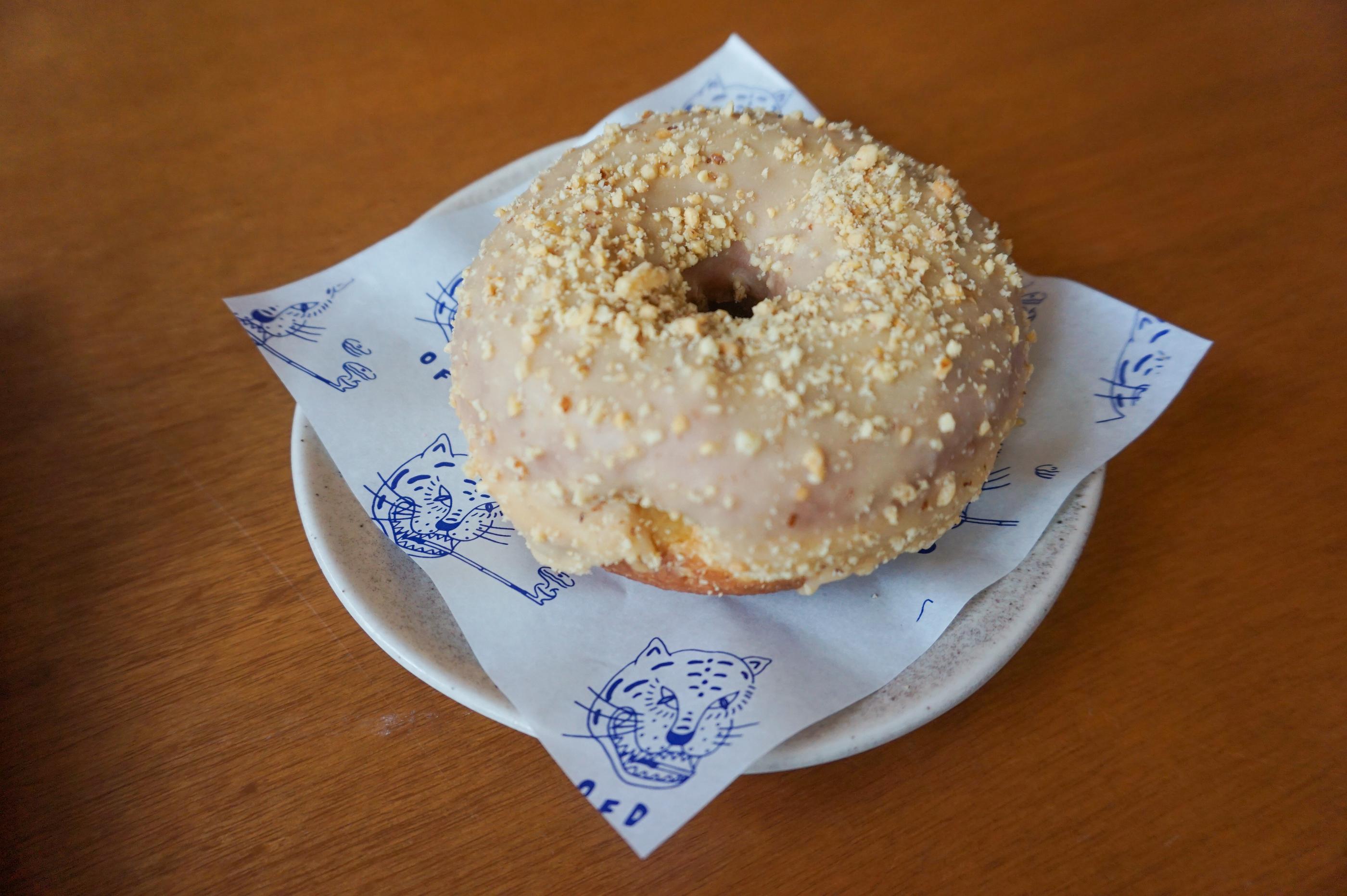 бөөрөн дээр няцлагдартай боовтой сахарын кестэл харуулсан Old Ferry Donut кафе.