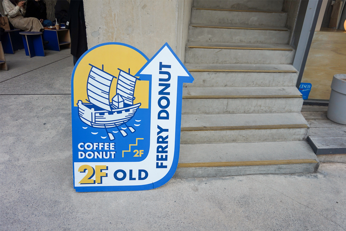 Old Ferry Donut咖啡馆的指示牌,上面显示二楼是咖啡和甜甜圈的用餐区域,并以一艘帆船的标志作为装饰。
