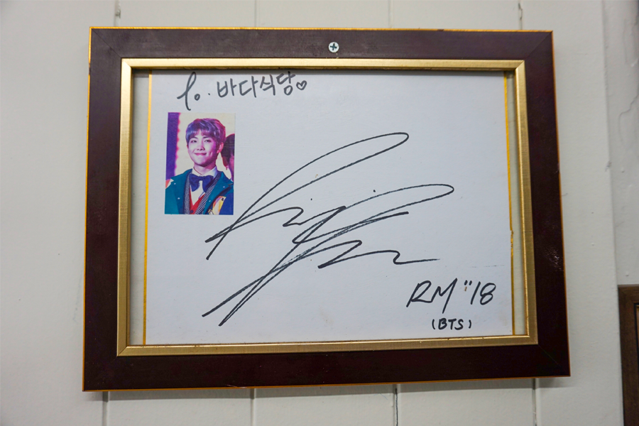 知名韩国男团BTS成员RM在大海食堂留下的签名，展现店内人气。