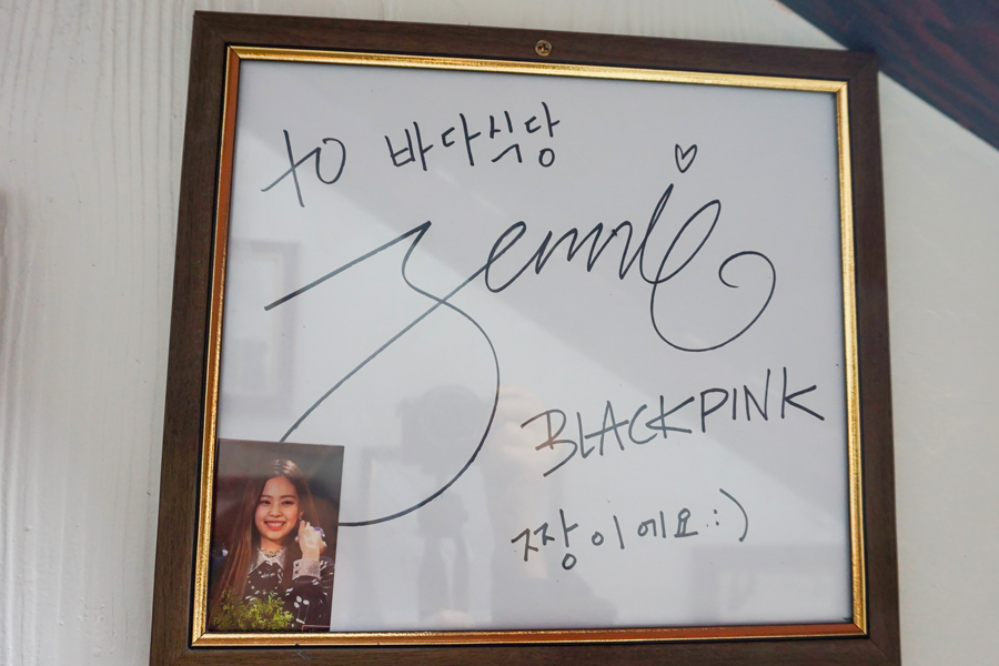 BLACKPINK成员Jennie在大海食堂的签名，吸引粉丝关注。